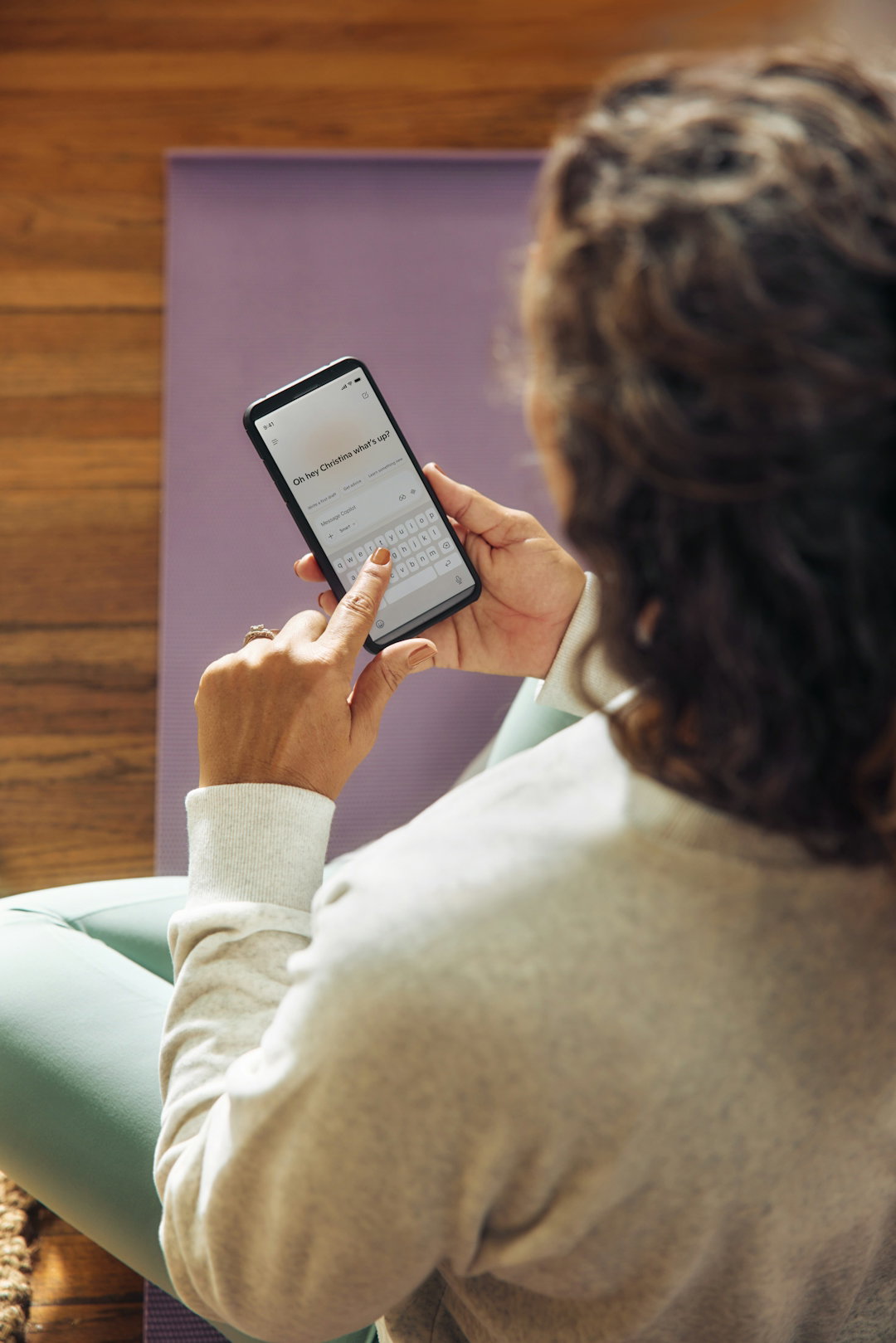 Woman using a smartphone on a yoga mat